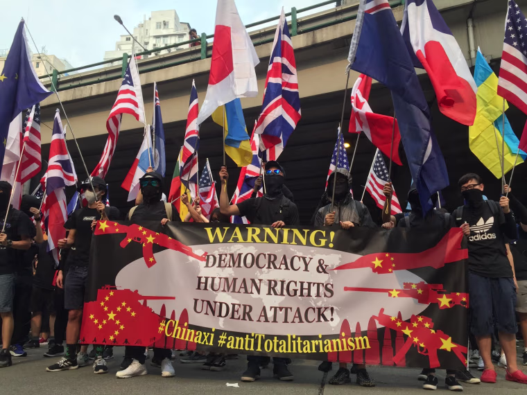 Protesters in Hong Kong marched Sunday with a banner denouncing what they claim is "Chinese totalitarianism."