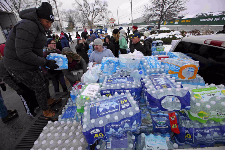 Image: Volunteers distribute bottled water to help combat the effects of the crisis when the citys drinking water became contaminated in Flint Michigan