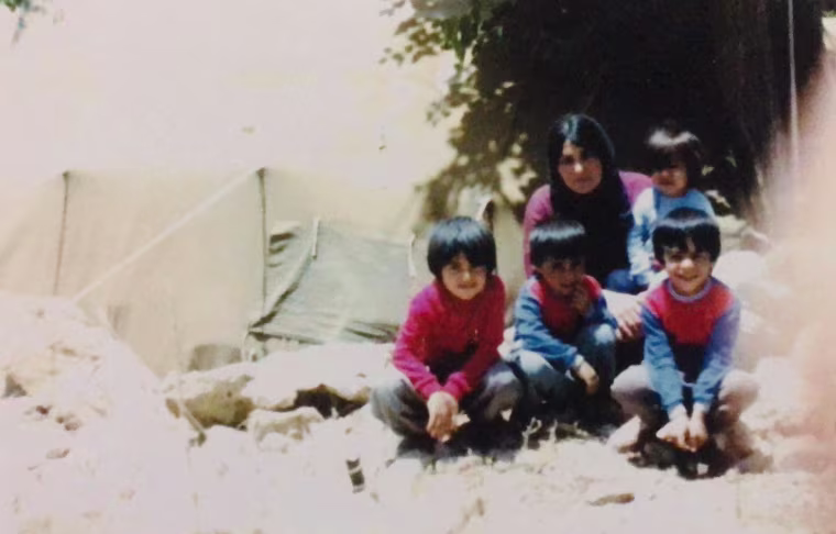 Yerevan Adham, left, is shown with his mother and three brothers at a refugee camp in Iran in 1987.