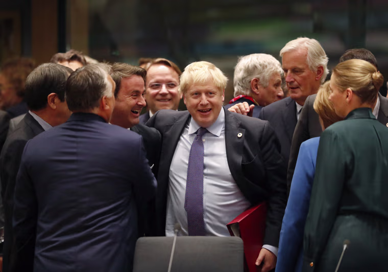 Image: British Prime Minister Boris Johnson, center, is greeted by Luxembourg's Prime Minister Xavier Bettel, center left, during a round table meeting at an EU summit in Brussels
