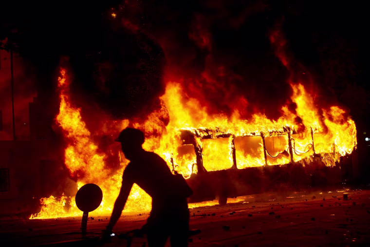 Image: A bus burns in downtown Santiago following a mass fare-dodging protest in Chile on Oct. 18, 2019.