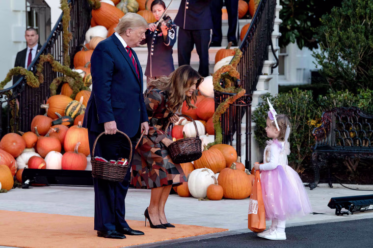 Image: President Trump and the first lady hand out Halloween candy to a little girl at the White House