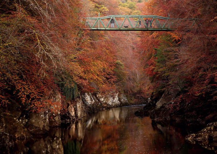 Image: People walk on the bridge over the river Garry, Pitlochry, Scotland