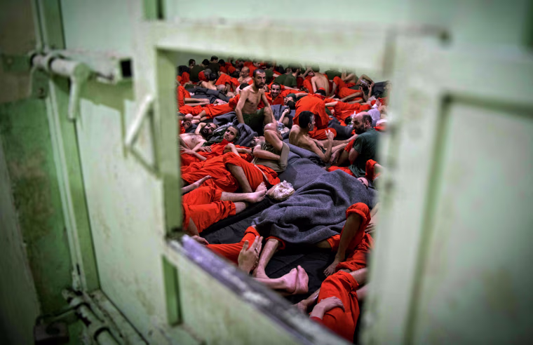 Image:Men suspected of being affiliated with ISIS sit in a prison cell in Hasakeh, Syria