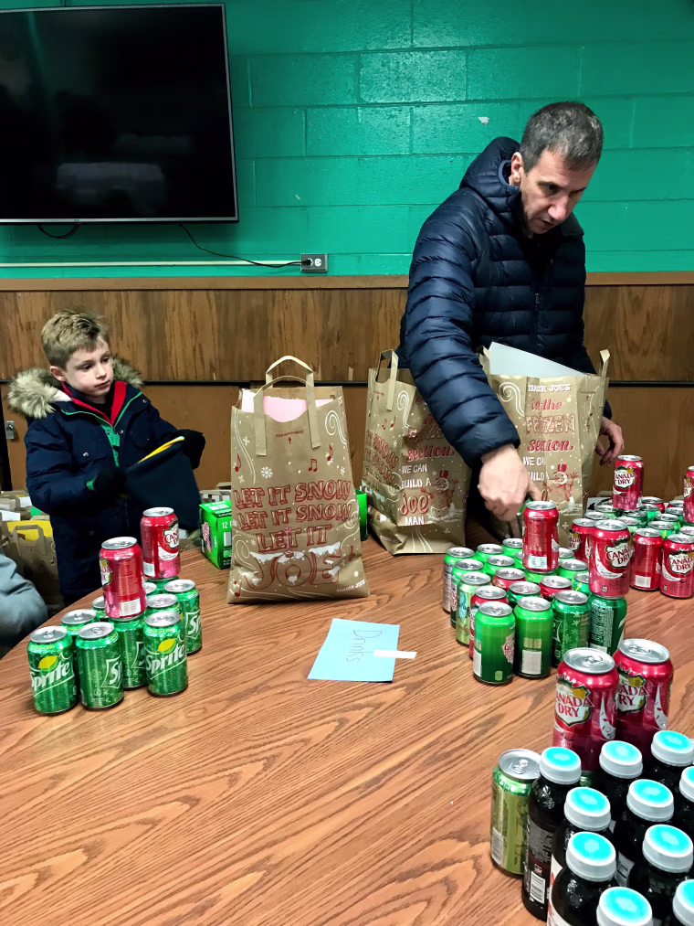 Koenig's son and husband bagging pre-cooked meals and beverages to deliver with Meals on Wheels.