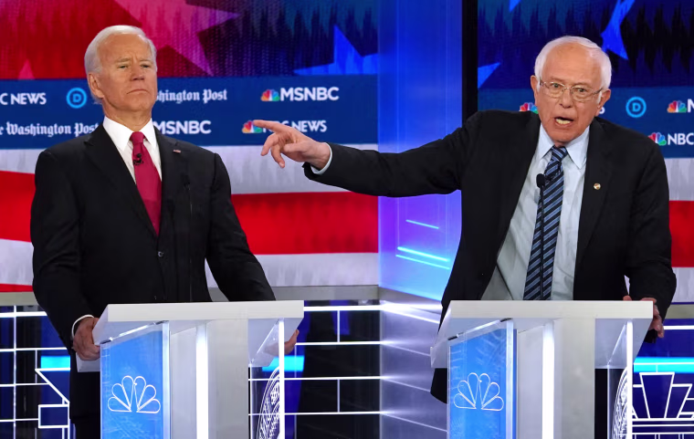 Image: Democratic presidential candidate former Vice President Joe Biden bends back to avoid the hand of Senator Bernie Sanders as Sanders points past Biden during the U.S. Democratic presidential candidates debate at the Tyler Perry Studios in Atlanta