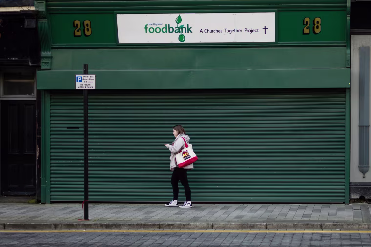 Image: A woman walks past a food bank in Hartlepool.