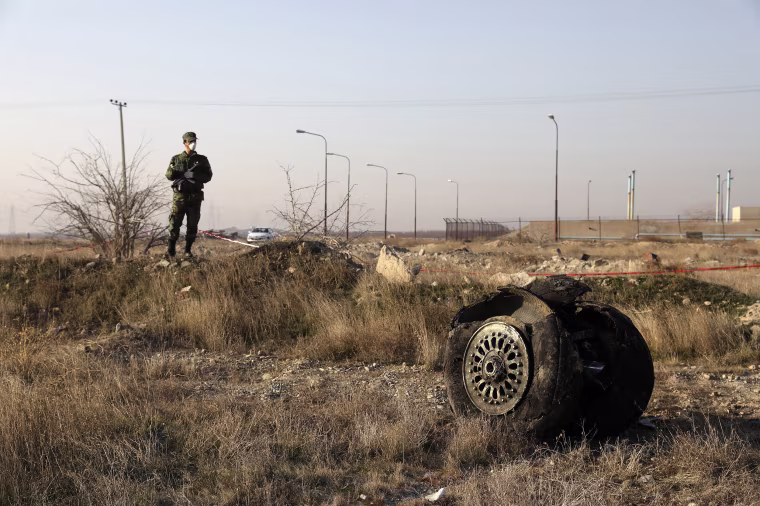 A police officer stands guard next to debris from an Ukrainian plane that crashed in Shahedshahr, southwest of the capital Tehran, Iran, on Jan. 8, 2020. A Ukrainian airplane carrying 176 people crashed on Wednesday shortly after takeoff from Tehran's main airport, killing all onboard.