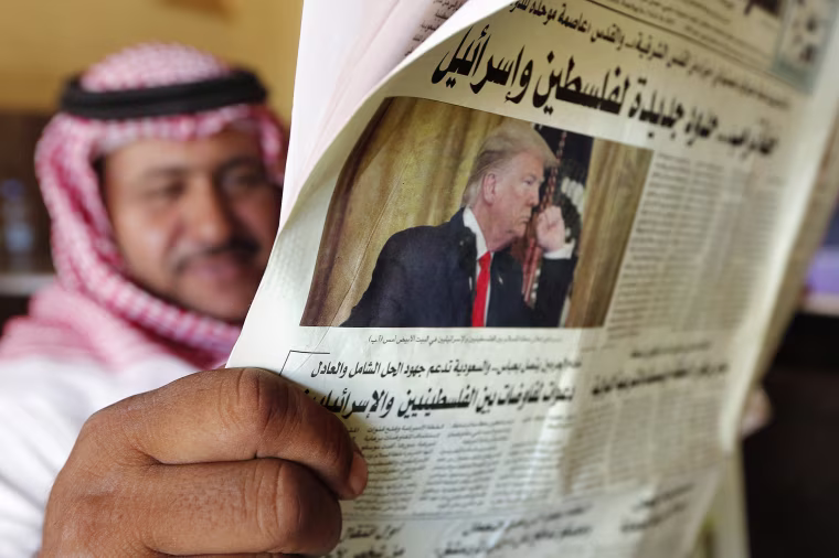 Image: A man holds the daily newspaper v