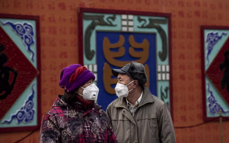 Image: A man and a woman wear protective masks in Beijing