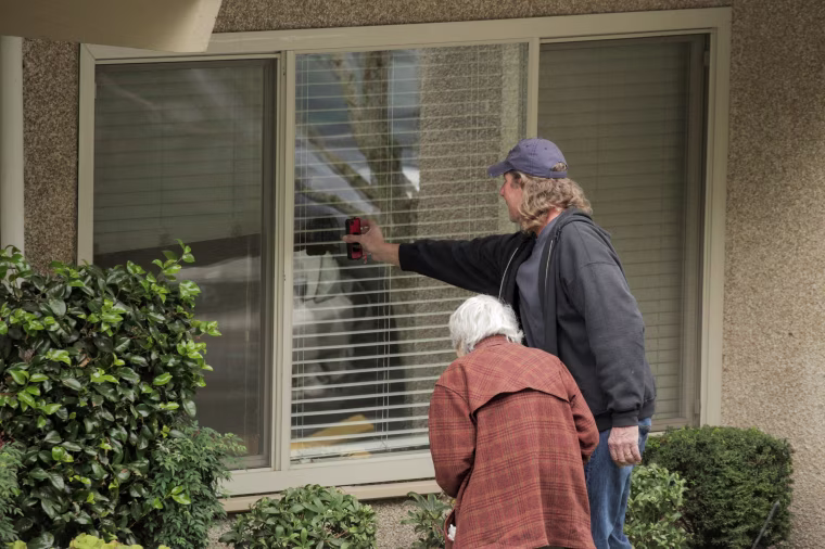 Image: Dorothy Campbell and her son, Charlie Campbell, talk through a window with her husband, Gene Campbell, at the Life Care Center of Kirkland, the long-term care facility linked to several confirmed coronavirus cases in the state, in Kirkland