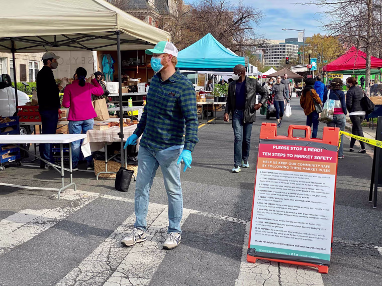 Image: Customers wearing masks walk through the Dupont Circle Market in Washington