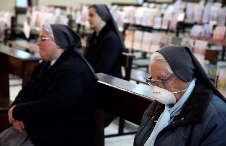 Image: Faithful attend a Holy Thursday Mass held by Father Fabio Vassallo in a nearly empty church in Catania, Italy.