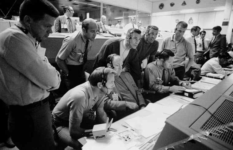 S70-34986 (14 April 1970) --- A group of six astronauts and two flight controllers monitor the console activity in the Mission Operations Control Room (MOCR) of the Mission Control Center (MCC) during the problem-plagued Apollo 13 lunar landing mission. Seated, left to right, are MOCR Guidance Officer Raymond F. Teague; astronaut Edgar D. Mitchell, Apollo 14 prime crew lunar module pilot; and astronaut Alan B. Shepard Jr., Apollo 14 prime crew commander. Standing, left to right, are scientist-astronaut Anthony W. England; astronaut Joe H. Engle, Apollo 14 backup crew lunar module pilot; astronaut Eugene A. Cernan, Apollo 14 backup crew commander; astronaut Ronald E. Evans, Apollo 14 backup crew command module pilot; and M.P. Frank, a flight controller. When this picture was made, the Apollo 13 moon landing had already been canceled, and the Apollo 13 crew men were in trans-Earth trajectory attempting to bring their damaged spacecraft back home.