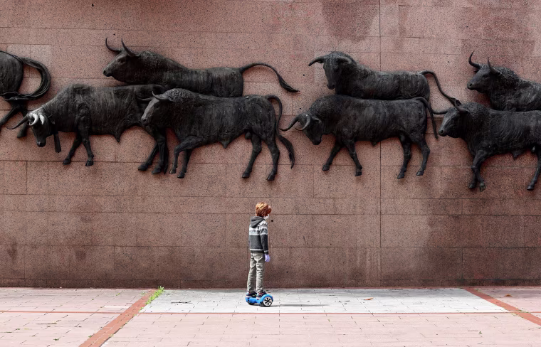 Image: A child on a hoverboard past the bulls sculptures outside Las Ventas bullring, after restrictions were partially lifted for children for the first time in six weeks, following the coronavirus disease (COVID-19) outbreak in Madrid,