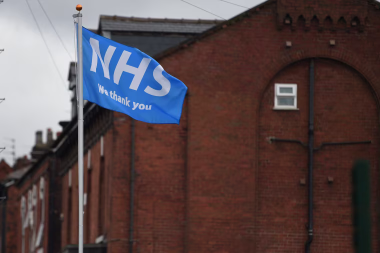Image: A flag displaying support for the National Health Service (NHS) flutters in Ashton-under-Lyne in Greater Manchester