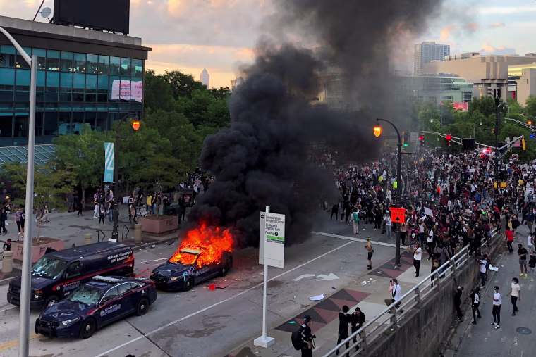 Image: An Atlanta Police car burns as people protest near CNN Center in Atlanta