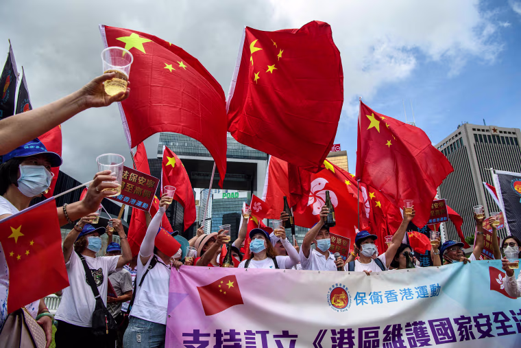 Image: Pro-China supporters display Chinese and Hong Kong flags as they raise a toast with champagne during a rally near the government headquarters in Hong Kong