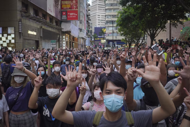 Image: Protesters against the new national security law march and gesture with five fingers, signifying the "Five demands - not one less" on the anniversary of Hong Kong's handover to China from Britain in Hong Kong