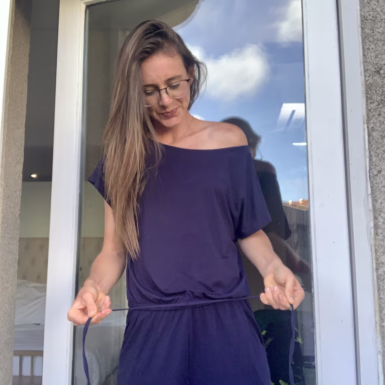 adjusting the drawstring on my off-shoulder jumpsuit