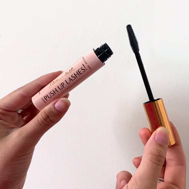 Woman holding tube of Charlotte Tilbury mascara