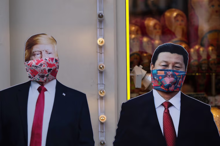 Image: Cardboard cutouts, displaying images of President Donald Trump and Chinese President Xi Jinping, with protective masks near a gift shop in Moscow