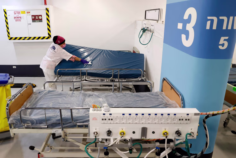 Image: A worker cleans a bed mattress in an underground parking lot that has been transformed into an intensive care facility for coronavirus patients in the Israeli city of Haifa.