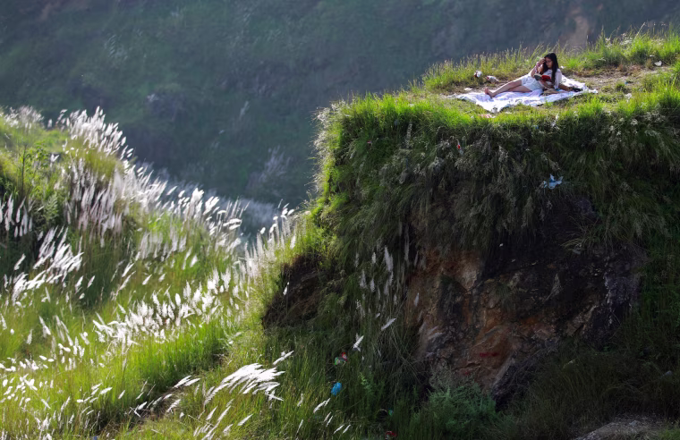 Image: A woman reads a book at Chobhar a picnic spot in Kathmandu