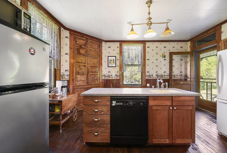 The kitchen has some new appliances but also features original woodwork and wallpaper.