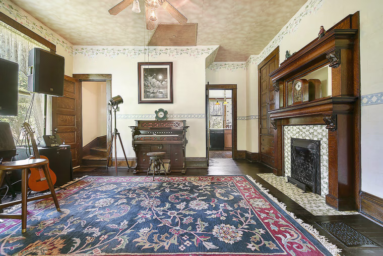 The home still has gorgeous original details like the fireplace in this room.