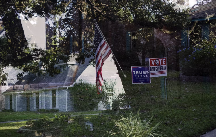 Image: Double exposure of Trump lawn signs and a house with an American flag