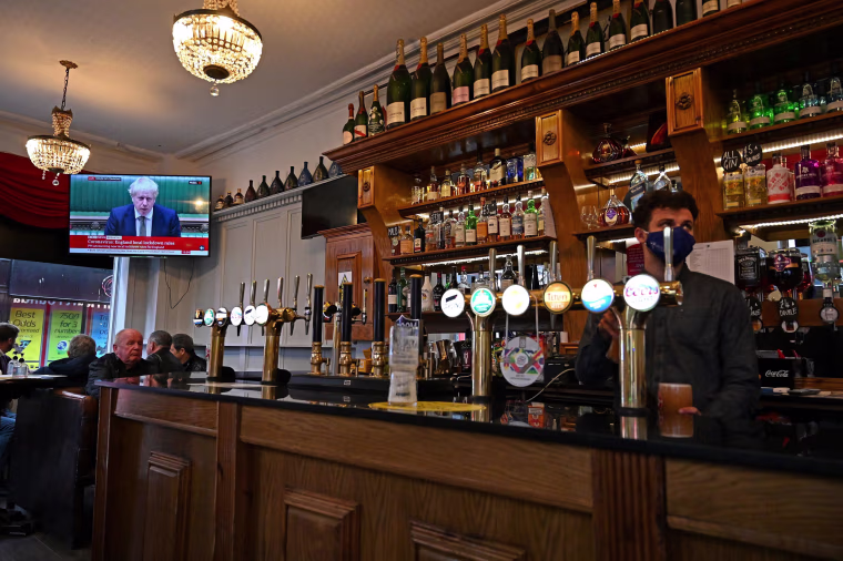 Image: A television shows Britain's Prime Minister Boris Johnson speaking in the House of Commons in London, as customers sit at tables inside the Richmond Pub in Liverpool, north west England