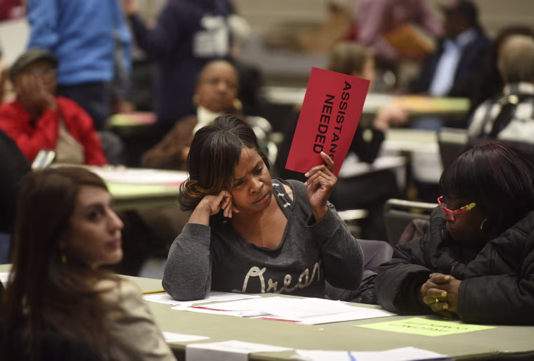 Vonettia Midgett, of Detroit, awaits assistance as the massive recounting of ballots begins for Wayne County's portion of the presidential election in Detroit on Dec. 6, 2016.