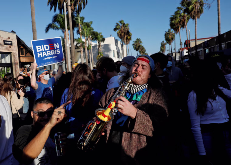 Image: People celebrate after media announced that Democratic U.S. presidential nominee Joe Biden has won the 2020 U.S. presidential election, at Venice Beach, California