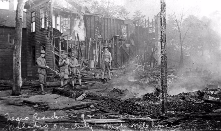 Illinois National Guard soldiers on duty among burned out residences.