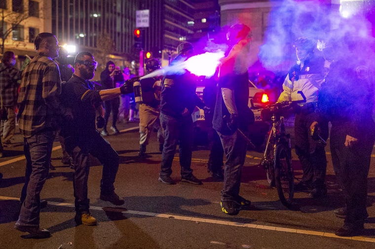 A member of the Proud Boys sprays a police officer with a chemical agent in downtown Washington as the group clashed continuously with counter-protesters on the evening of the second Million MAGA March in on Dec. 12, 2020.