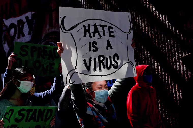 Image: People hold placards during a \"Stop Asian Hate\" rally, following the deadly shootings, in Atlanta on March 20, 2021.
