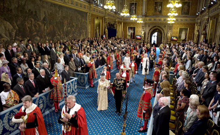 Britain's Queen Elizabeth II and Prince Philip walk through the Royal Gallery in the Palace of Westminster during the State Opening of Parliament, in London, on May 25, 2010.