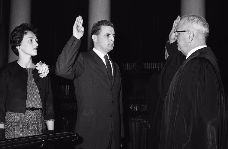 Walter Mondale, center, newly appointed Minnesota attorney general, repeats his oath of office as Minnesota Supreme Court Chief Justice Roger Dell swears him into office at the Capitol in St. Paul on May 5, 1960. Mondale's wife, Joan Mondale looks on at left.