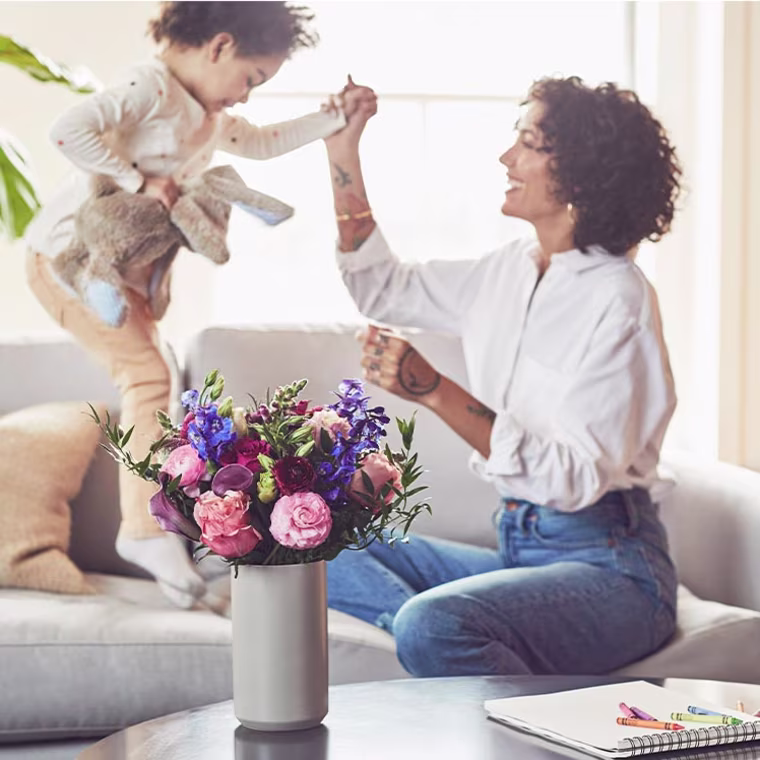Mother Playing with her son, with flowers in front of her