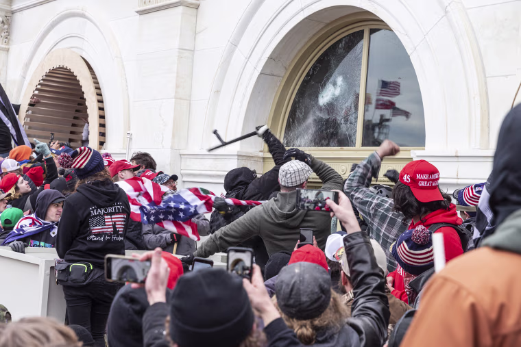 Pro-Trump protesters break windows of the Capitol building.