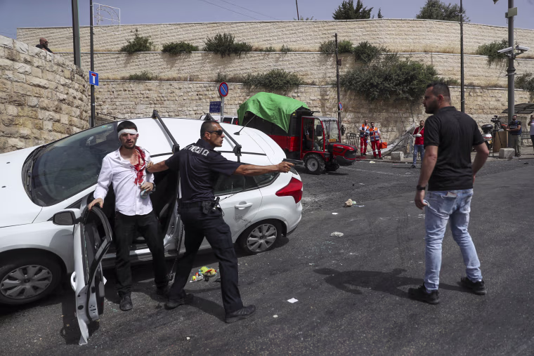 Image: An Israeli police officer protects a Jewish driver