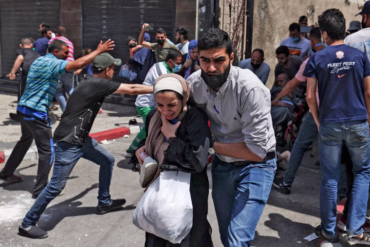 Palestinians evacuate a building targeted by Israeli bombardment in Gaza City on May 11, 2021.