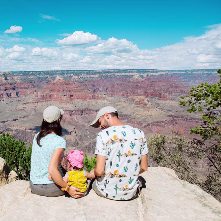 Family sitting on the edge of cliff in Grand Canyon National Park