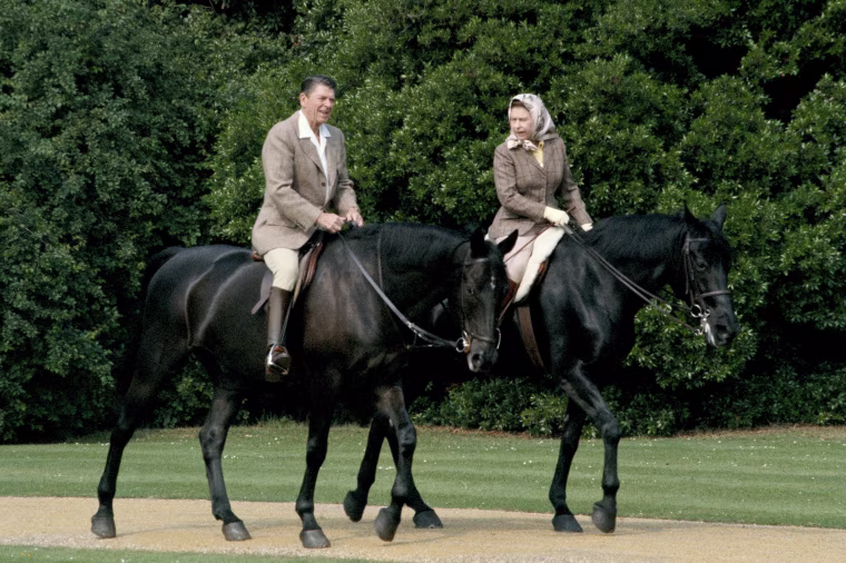 Queen Elizabeth II riding in the grounds of Windsor Castle with President Ronald Reagan, during his state visit to the UK, June 8, 1982. She is riding her horse 'Burmese' and he is mounted on 'Centennial', both gifts to the Queen from the Canadian Mounted Police.