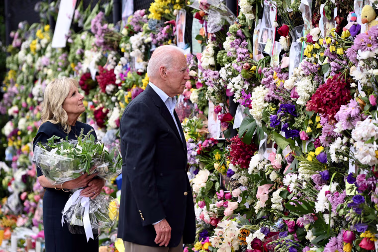 Image: President Joe Biden and first lady Jill Biden visit a photo wall, the 'Surfside Wall of Hope and Memorial', near the partially collapsed 12-story Champlain Towers South condo building in Surfside, Fla., July 1, 2021.