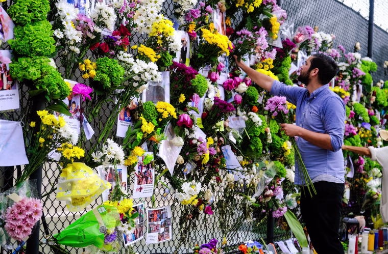 Image: Leo Soto places flowers onto a makeshift memorial