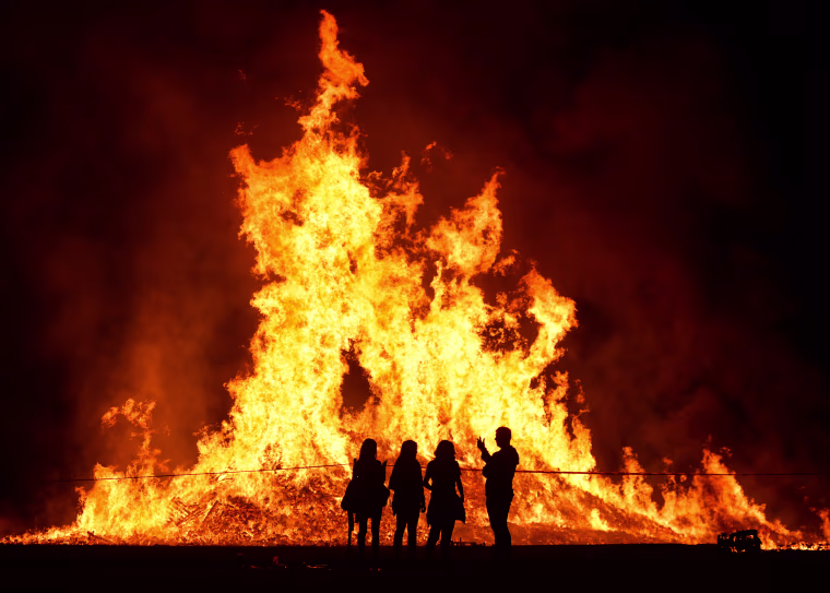 Image: People in front of a bonfire during the Eleventh Night marking the start of the unionist Twelfth celebrations, in Craigy Hill, Larne