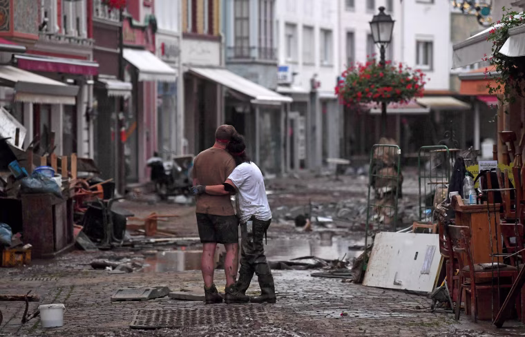 A couple hug as they stand amid debris in Bad Neuenahr-Ahrweiler on July 15, 2021.