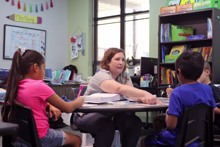 Rebecca Young works on phonics with several rising first grade students during a summer school program at River Bend Elementary in College Station, Texas.